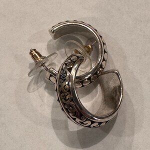 Silver-tone hoop earrings with an engraved decorative pattern.